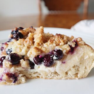 A piece of blueberry dessert pizza on a white plate.