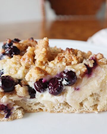 A piece of blueberry dessert pizza on a white plate.