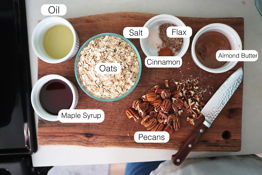 Ingredients for quick skillet granola laid out on a wood cutting board and labeled.