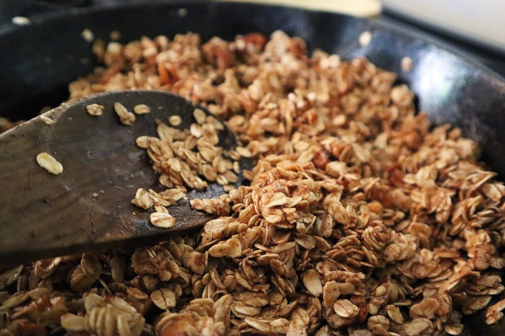 Stirring all skillet granola ingredients in the iron skillet until it is coated well.