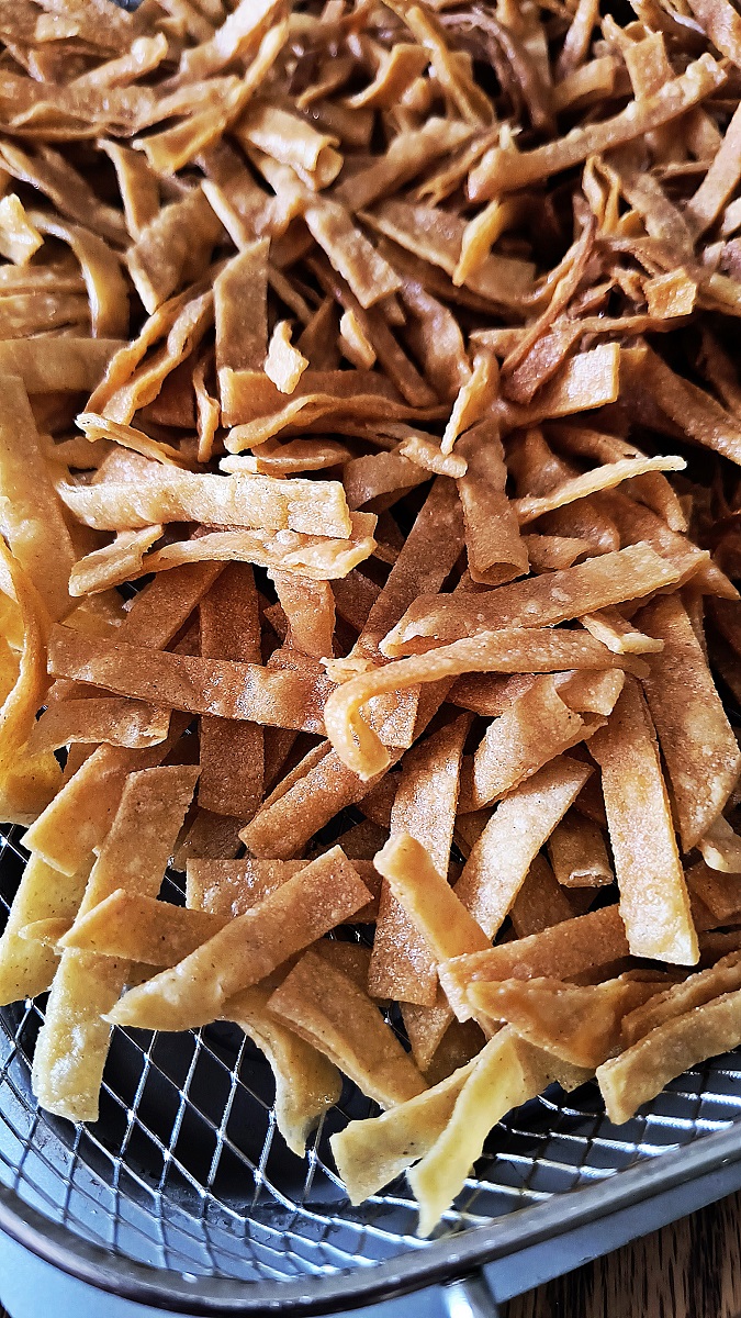 Close up photo of fried corn chips for homemade chili sitting on a straining rack.